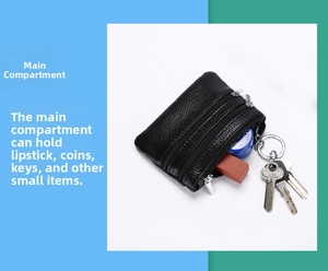 Detail of black leather coin purse with triple zipper pockets and metal keychain