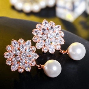 Macro shot of rose gold flower earrings with marquise cubic zirconia and pearls