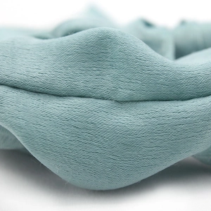 Detail shot of mint green pleated knit scrunchie texture with soft ribbed fabric