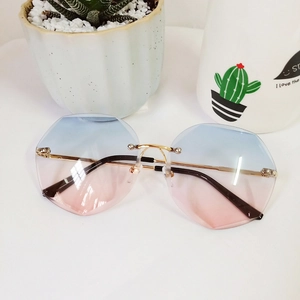 Macro detail of rimless polygonal sunglasses with blue-pink gradient lenses and gold frame