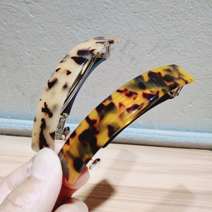 Macro detail of tortoiseshell hair clips showing acetate texture and metal spring mechanism