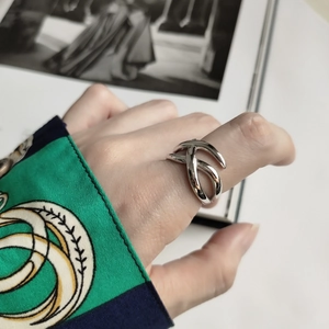 Macro shot of silver woven knot ring design showcasing modern minimalist hollow details