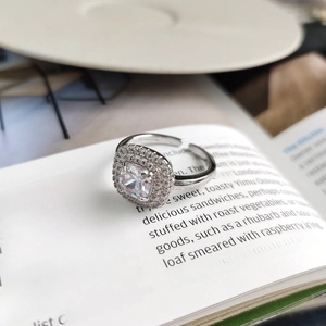 Square-cut S925 sterling silver ring with double halo crystals on an open book