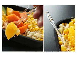 Detail of transparent plastic fruit fork with non-slip handle and double prong design