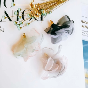Flat lay of colorful chiffon petal tassel earrings with elegant golden metal caps