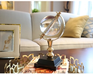 Detailed view of luxury crystal globe with golden metal stand on a black tiered pedestal