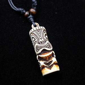 Close-up of Tiki totem pendant with bone-like texture and black woven rope detail