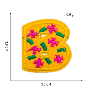 Detail of embroidered letter B patch in yellow felt with pink and green texture