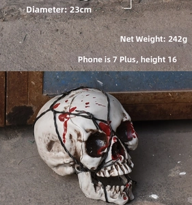 Close-up of 23cm realistic Halloween skull with red blood stains and barbed wire detail