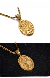 Detail of a vintage gold-plated oval pendant featuring an embossed Saint Mary figure