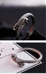 Macro shot of stainless steel cable twist bracelet with skull heads in punk style