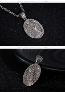 Detail of silver oval medallion pendant with relief design and Greek key border on rope chain
