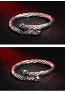 Detailed macro view of silver stainless steel twisted wire cable bracelet with skull heads