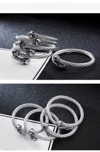 Close-up of gothic stainless steel skull bangle with twisted wire rope texture