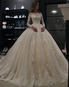 Détails de broderie en dentelle sur manches longues et robe de mariée champagne col bardot