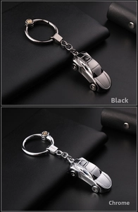 Detail of sleek metal car keychains in black and chrome with LED light and engraved logo