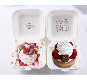Eco-friendly white pulp burger box with strawberry cake and tart in overhead view