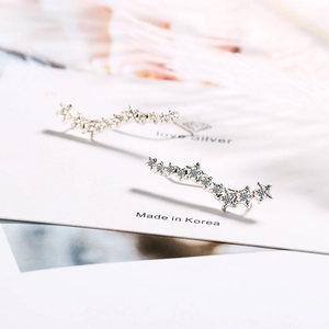 Sparkling silver star-shaped long earrings with crystals on a minimalist display card