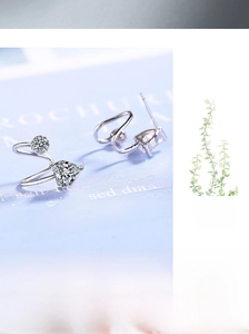 Macro shot of silver heart-shaped and round crystal studs on a soft blue background