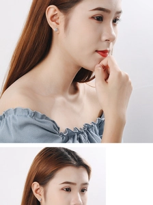 Detailed close-up of a silver sun flower stud earring with small crystals on model ear