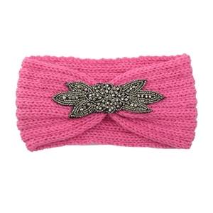 Detail eines rosa Strickstirnbands mit handgenähten silbernen Perlen in Blattform