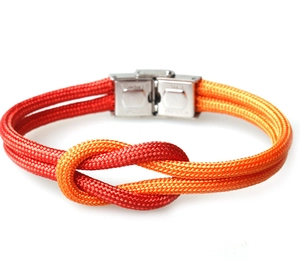 Close-up of double-braided nautical bracelet with orange gradient cord and silver buckle