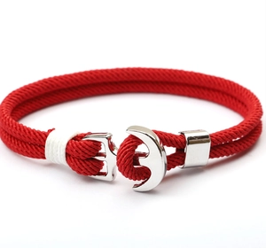 Detail of red nautical paracord bracelet with silver anchor clasp on white background