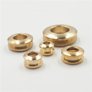 Detail showing five different sizes of round brass eyelet screw grommets on white background