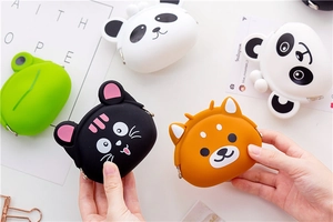 Handheld view of mini cartoon silicone coin purses in cat and panda animal shapes