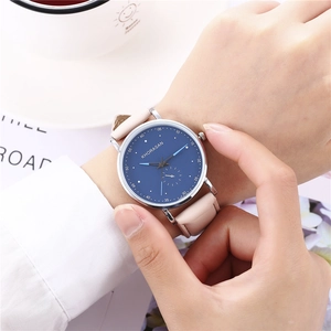 Vue détaillée du cadran bleu foncé de la montre à quartz avec bracelet en cuir rose clair