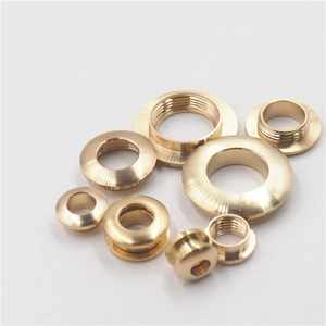 Polished brass eyelet screw grommets for clothing and leather bags on white background