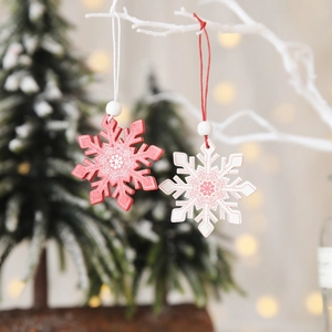 Red and white snowflake Christmas ornaments hanging on a white branch with festive lighting