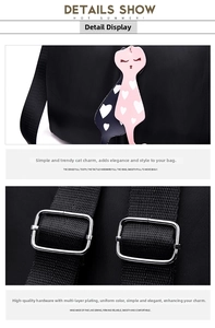 Detail of black nylon backpack featuring a cute cat pendant and silver metal adjusters