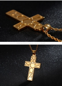 Detailed close-up of golden stainless steel cross pendant with textured cell pattern