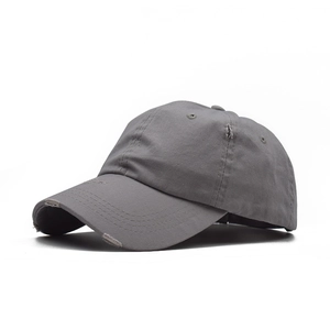 Detail of distressed cotton baseball cap with vintage rips and frayed brim in dark grey