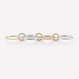 Detail of interlocking gold diamond rings and silver bands in a chain formation