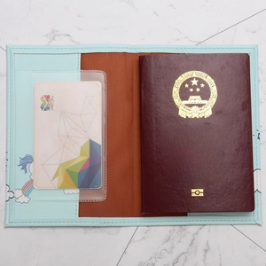 Close-up of light blue unicorn passport cover with card slots and inner leather lining