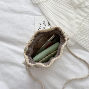 Woven straw bucket bag with green flower embroidery and crossbody drawstring strap