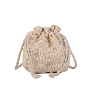 Beige woven drawstring bucket bag featuring floral embroidery and cotton rope straps