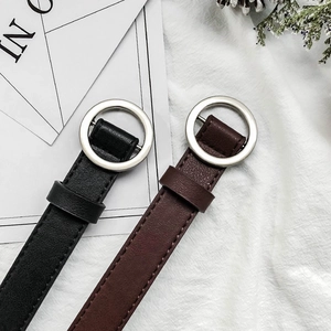 Detail of slim black and brown PU leather belts with silver round buckles and stitching