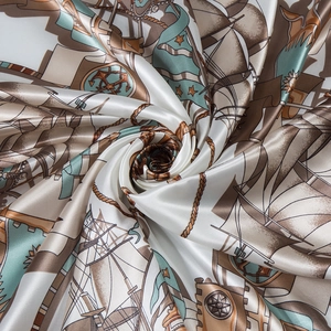 Detailed macro view of silk scarf fabric showing nautical sailboat and anchor patterns