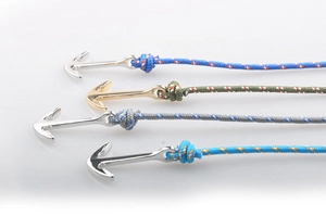 Détail de quatre bracelets nautiques tressés à la main avec ancres en bleu, vert et gris