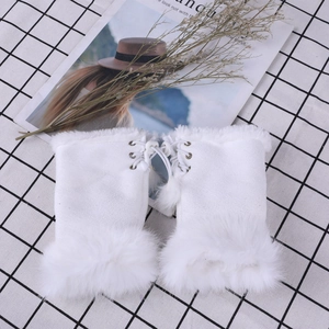 Detail of white faux fur fingerless gloves featuring stylish lace-up ribbons and pom-poms