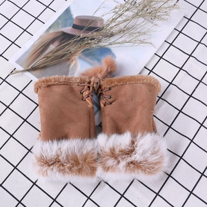 Macro detail of brown suede winter gloves featuring fluffy faux fur trim and lace-up design