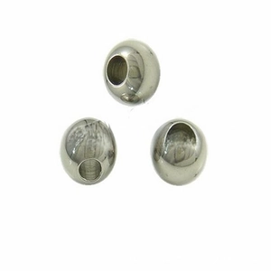 Close-up of three polished stainless steel spacer beads with central holes for jewelry DIY