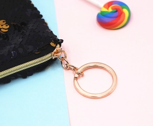 Detailopname van een modieuze zwarte pailletten make-up tas met gouden rits en ring