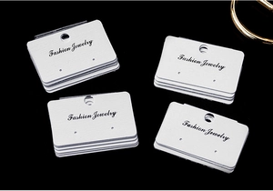 Stack of white PVC earring display cards with Fashion Jewelry print on black background