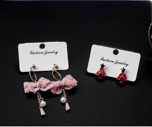Detail view of pink lace bow earrings and festive crystal tree studs on display cards