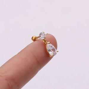 Detailed view of a gold flower pendant cartilage stud earring with pear shaped zircon