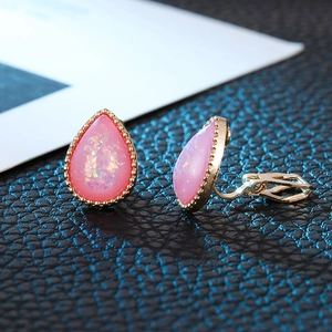 Detailed macro view of pink teardrop clip-on earrings with shimmering crystal finish